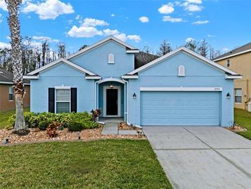 Charming one-story blue home with a well-manicured lawn and a two-car garage at 3773 Moon Dancer Pl, St Cloud, FL 34772