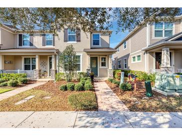 Charming townhouse with a well-manicured lawn and inviting walkway and beautiful blue door at 8375 Lovett Ave, Orlando, FL 32832