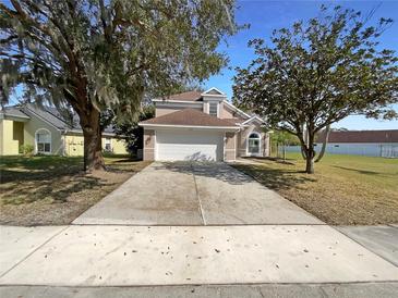 Two-story house with a two-car garage and manicured lawn at 8920 Fort Jefferson Blvd, Orlando, FL 32822