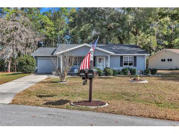 Ranch-style home with gray siding, front porch, and landscaped yard at 10897 Sw 80Th Ct, Ocala, FL 34481