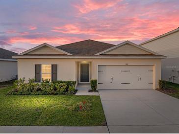 Charming single-story home featuring a well-manicured lawn and an attached two-car garage at 1207 Tank Trl, Haines City, FL 33844