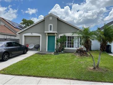 One story house with teal door, attached garage, and well-maintained lawn at 1417 Brookebridge Dr, Orlando, FL 32825