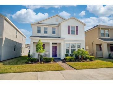 Charming two-story home with a well-maintained lawn and a welcoming purple front door at 16560 Point Rock Dr, Winter Garden, FL 34787