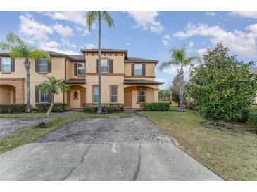 Charming townhome featuring a welcoming entrance, a neatly maintained lawn, and vibrant palm trees at 2153 Calabria Ave, Davenport, FL 33897