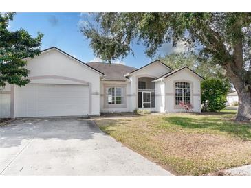 Inviting single-story home with a two-car garage and mature trees in a manicured front yard at 421 Boxwood Dr, Davenport, FL 33837