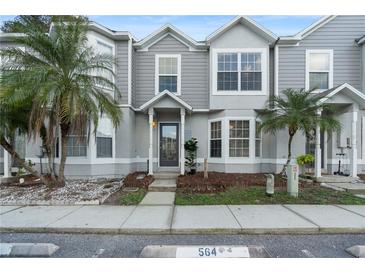 Charming townhome with neat landscaping, a covered porch, and palm trees in the front yard at 564 Shadow Glenn Pl, Winter Springs, FL 32708