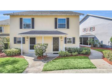 Charming two-story townhome featuring a well-maintained lawn and inviting front porch at 1220 Villa Ln # 135, Apopka, FL 32712