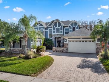 Stunning two-story home with a three-car garage, brick driveway, and beautifully landscaped front yard at 16315 Bristol Lake Cir, Orlando, FL 32828