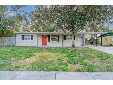 Charming single story home with well-kept lawn and a bright red front door at 4108 Westgate Rd, Orlando, FL 32808