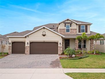 Charming two-story home features a three-car garage, stone accents, and a well-manicured front yard at 739 Annabell Ridge Rd, Minneola, FL 34715