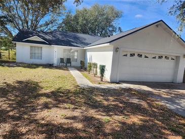 Well-maintained single-story home with a lush front yard and an attached two-car garage at 11618 Kipling Ct, Clermont, FL 34711