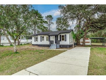 Charming single-story home boasts a well-maintained lawn and updated exterior paint at 11822 County Road 561, Clermont, FL 34711