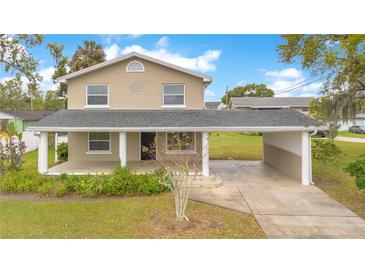 Charming two-story home featuring a covered porch and carport, set in a lush green lawn at 1604 Roosevelt Ave, Orlando, FL 32804