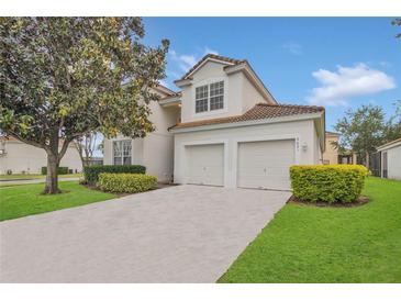Charming two-story home with a two-car garage, lush landscaping, and a well-maintained lawn at 2621 Archfeld Blvd, Kissimmee, FL 34747