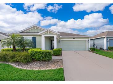 Charming single-story home with green siding, well-manicured landscaping, and a two-car garage at 4418 Blackbird St, Kissimmee, FL 34746