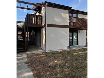 Exterior view of a two-story building featuring a balcony, painted stucco, and dark brown trim at 4903 Lake Ridge Rd # Ge, Orlando, FL 32808