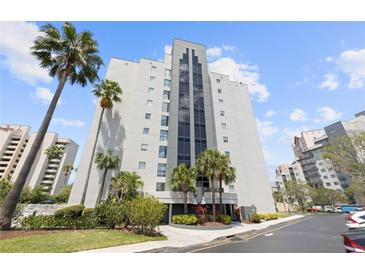 Modern high-rise building with elegant landscaping and tall palm trees, providing a luxurious and inviting curb appeal at 6165 Carrier Dr # 2306, Orlando, FL 32819