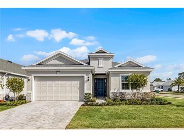 Beautiful single-story home with neutral paint, manicured lawn, and a two car garage at 8456 Norwich Way, Mount Dora, FL 32757