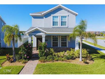 Charming two-story home with a landscaped front yard and covered porch with brick walkway at 9862 Pecan Hickory Way, Orlando, FL 32832