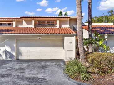 Charming two-story home with a two-car garage, terracotta roof, and lush, tropical landscaping at 176 Balfour Dr # 4, Winter Park, FL 32792