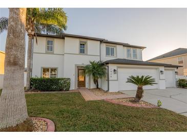 Charming two-story home with a well-maintained lawn, decorative landscaping, and a three car garage at 1926 Binnacle St, Kissimmee, FL 34744