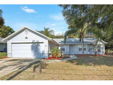 Charming single-story home with a well-manicured lawn and a two-car attached garage at 1995 Brewster Dr, Deltona, FL 32738