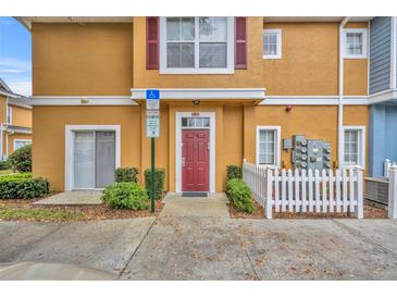 Charming townhome with a red front door, white picket fence, and well-maintained landscaping at 2280 San Vital Dr # 108, Kissimmee, FL 34741