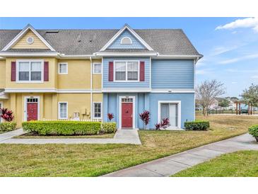 Charming two-story townhome with colorful exterior, well-manicured lawn, and inviting entrance at 4012 Santa Maria Dr # 102, Kissimmee, FL 34741