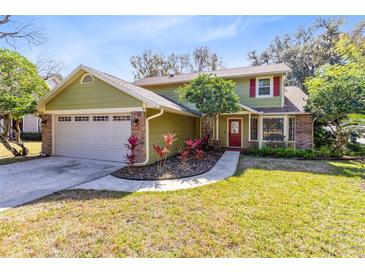 Charming two-story home with attached garage and a well-manicured front yard with mature trees at 8413 Commander Cv, Winter Park, FL 32792