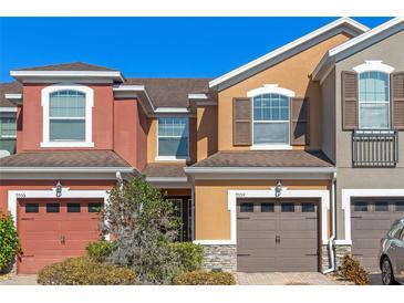 Townhome with a well-maintained front yard and attached garages at 9559 Silver Buttonwood St, Orlando, FL 32832