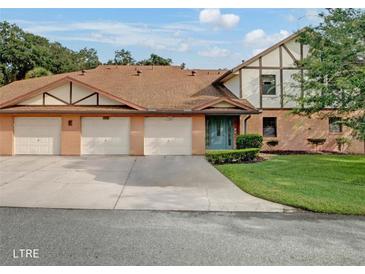 Charming townhome with attached garages, brick facade, and a well-manicured lawn at 100 E Oak Terrace Dr # 1, Leesburg, FL 34748