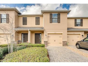 Inviting townhouse with brick-paved driveway and manicured landscaping at 1558 Downy Birch Ln, Longwood, FL 32750