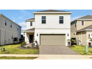 Charming two-story home featuring a neutral color palette, attached garage, and a well-manicured front yard at 16207 Trinidad Way, Clermont, FL 34714