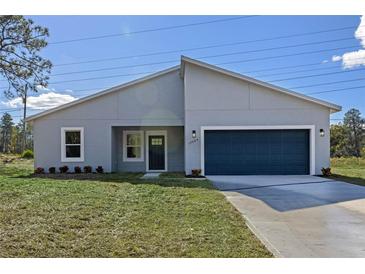 Charming single-story home featuring a two-car garage, well-manicured lawn, and freshly painted exterior at 170 Marion Oaks Ln, Ocala, FL 34473