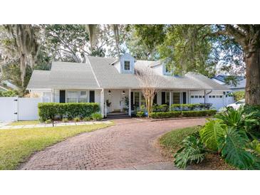 Charming home featuring a circular brick driveway, manicured landscaping, and a bright white exterior at 181 N Phelps Ave, Winter Park, FL 32789