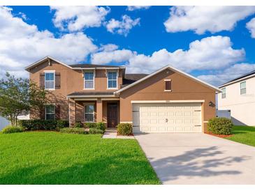 Charming two-story home with a well-maintained lawn, inviting curb appeal, and an attached two-car garage at 1920 Partin Terrace Rd, Kissimmee, FL 34744