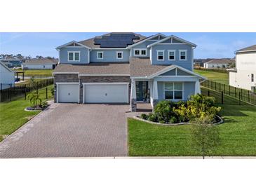 Charming two-story home showcasing a three-car garage and a beautifully landscaped front yard at 4228 Sunset Preserve Blvd, Orlando, FL 32820