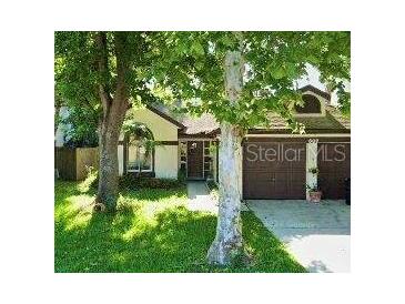 Charming single-story home featuring a two-car garage and a well-maintained front yard with mature trees at 609 Charing Cross Ct, Lake Mary, FL 32746