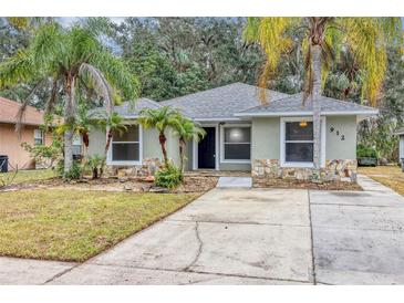 Charming single-story home with a well-manicured lawn and mature palm trees creating curb appeal at 912 Enterprise Ave, New Smyrna Beach, FL 32168