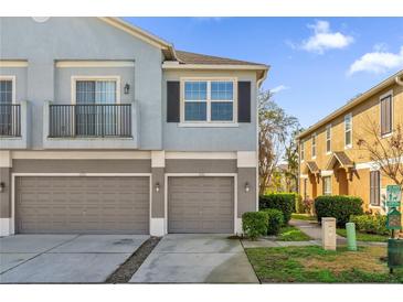 Two-story townhome featuring individual garages, a balcony and muted blue and gray color scheme at 1710 San Jacinto Cir # 1710, Sanford, FL 32771