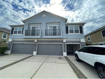 Three-story condo featuring a three-car garage, balconies, and neutral-colored facade at 1710 San Jacinto Cir # 1710, Sanford, FL 32771