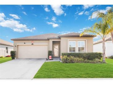 Charming single-story home featuring manicured landscaping, neutral tones, and a spacious two-car garage at 2857 Neverland Dr, New Smyrna Beach, FL 32168