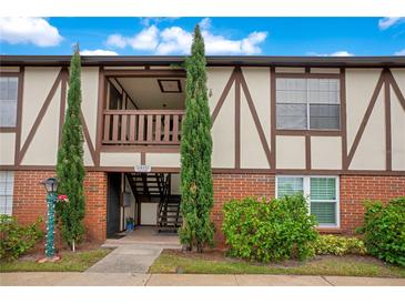 Charming condo exterior featuring a brick facade, Tudor accents, and well-maintained landscaping at 5405 Hansel Ave # G9, Orlando, FL 32809