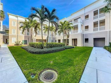 Beautiful courtyard featuring lush green landscaping and mature palm trees adds to the community's ambiance at 580 Water St # F, Kissimmee, FL 34747