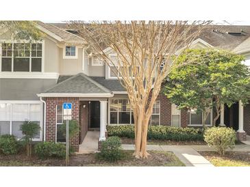 Inviting townhome with well-maintained landscaping, a brick facade, and convenient parking at 11901 Sandy Knoll Ct # 814, Orlando, FL 32825