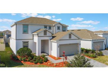 Well-kept two-story home with a brown roof and manicured landscaping in the front yard at 1260 Tupelo Trl, Haines City, FL 33844