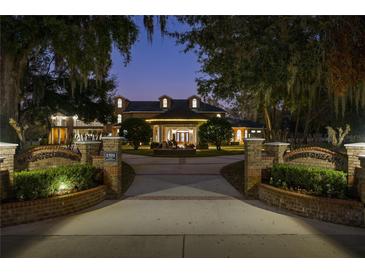 Beautiful estate home featuring brick entrance with landscaped garden, water feature, and manicured grounds in the evening light at 1501 Lake Markham Rd, Sanford, FL 32771