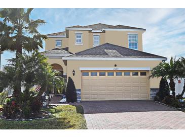 Charming two-story home featuring a two-car garage, brick driveway, and lush tropical landscaping at 2659 Magpie Way, Sanford, FL 32773