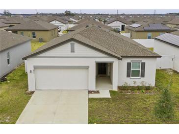 Charming single-story home with a two-car garage and neutral-colored exterior in a Gathering-friendly neighborhood at 5861 Bar Ranch Rd, St Cloud, FL 34771
