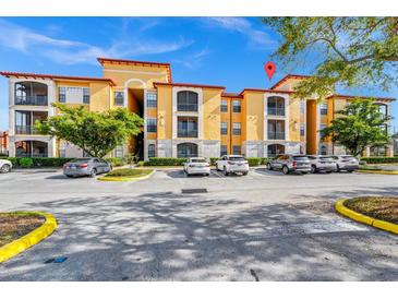 Yellow condo building with stone accents, balconies, and well-maintained landscaping provides a beautiful exterior view at 6157 Metrowest Blvd # 106, Orlando, FL 32835